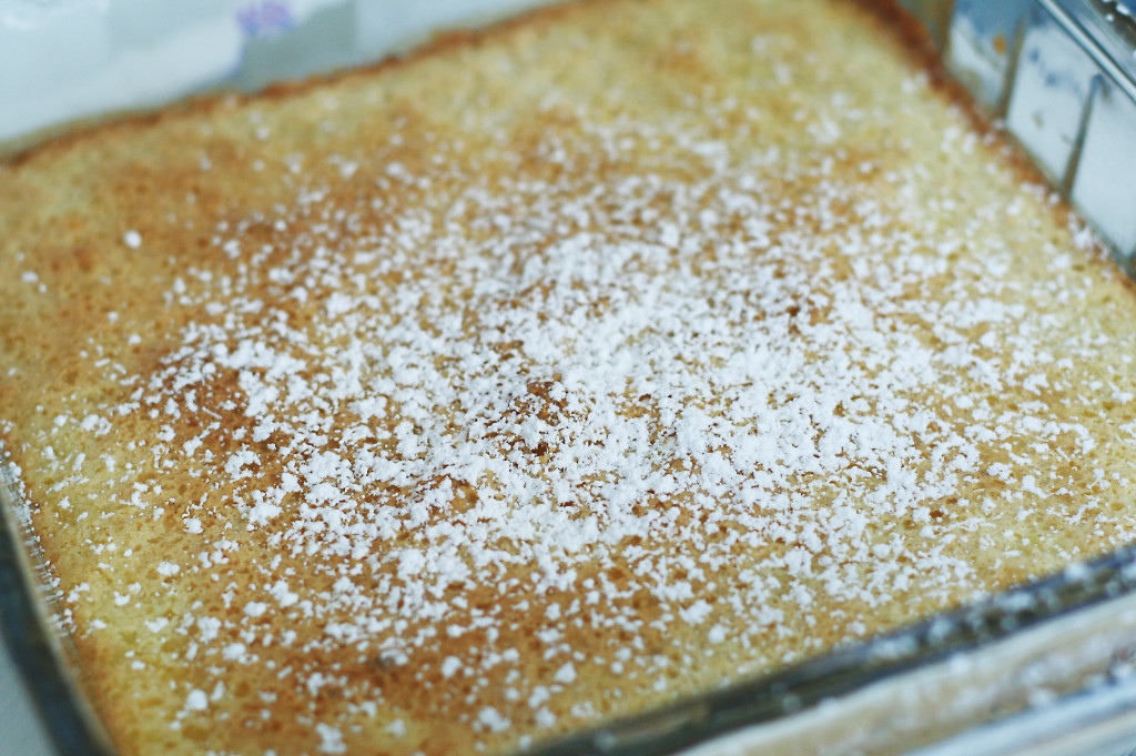 sprinkling powdered sugar over lemon bars